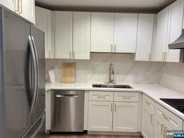 a kitchen with white cabinets and a refrigerator