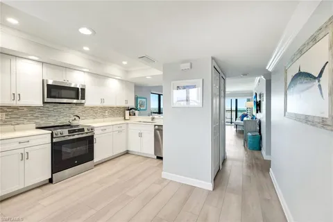 a large kitchen with a sink stainless steel appliances and cabinets