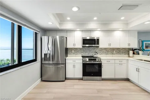 a large kitchen with a stove top oven a refrigerator and a sink