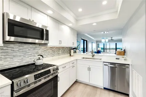 a kitchen with stainless steel appliances a sink dishwasher a stove microwave and cabinets