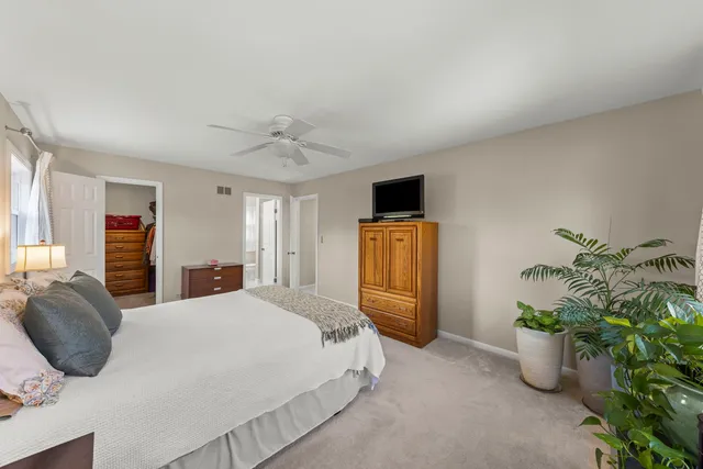 a bedroom with a bed and a potted plant