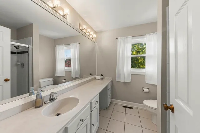 a bathroom with a granite countertop sink mirror and a bathtub