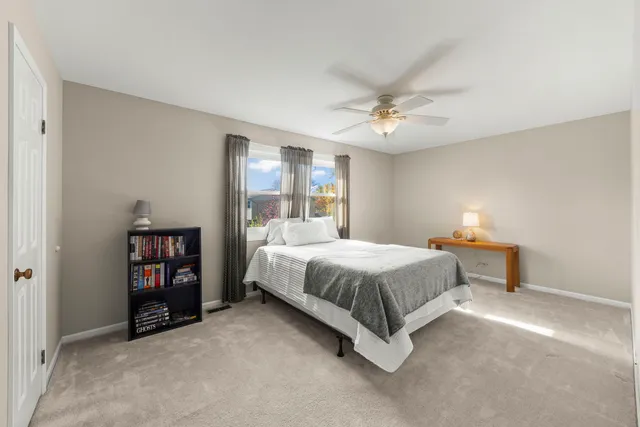 a spacious bedroom with a bed and a book shelf