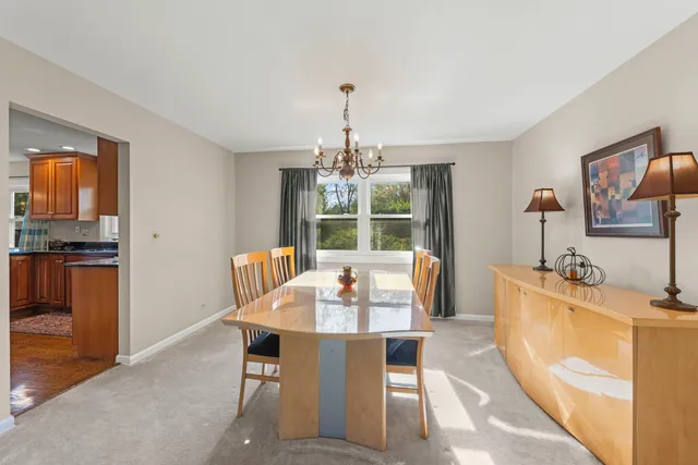 a dining room with furniture a chandelier and window