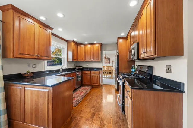 a kitchen with granite countertop a sink a stove and cabinets