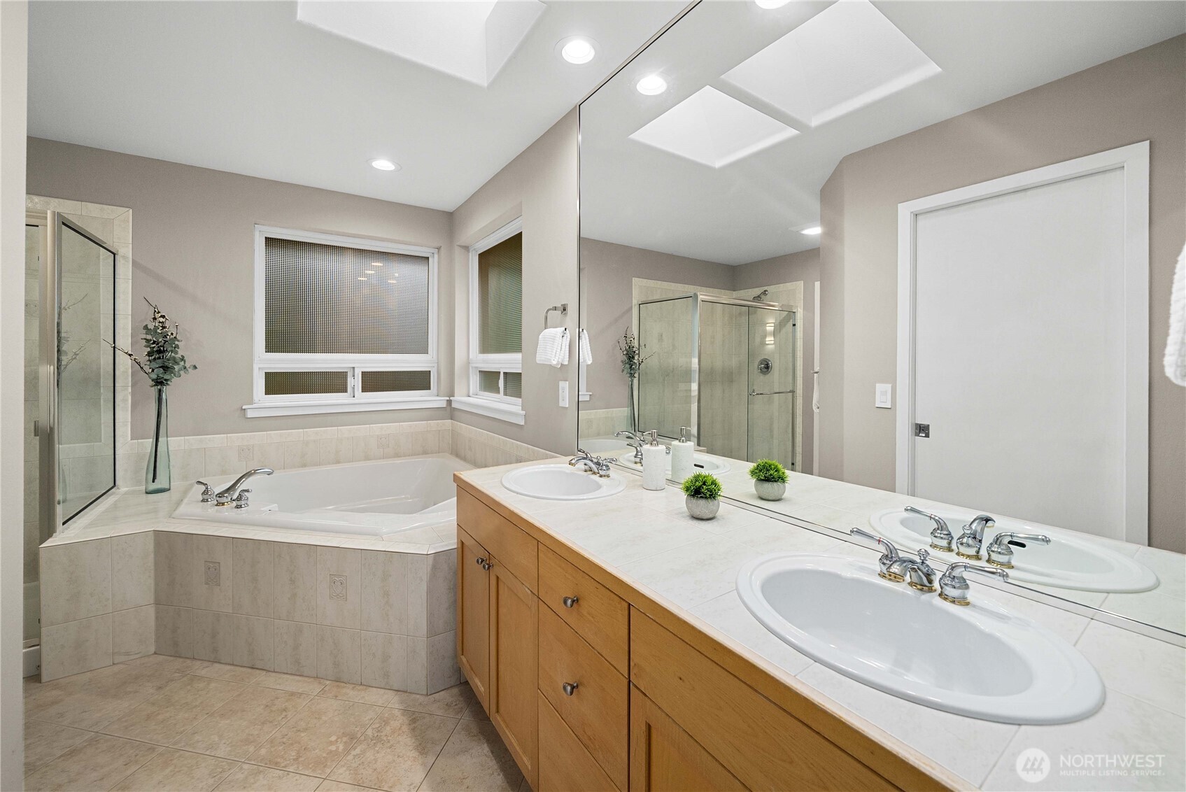25010 235th Court Southeast Maple Valley, WA 98038 - Photo 28 of 40 a bathroom with double vanity sinks double vanity tub shower and a mirror