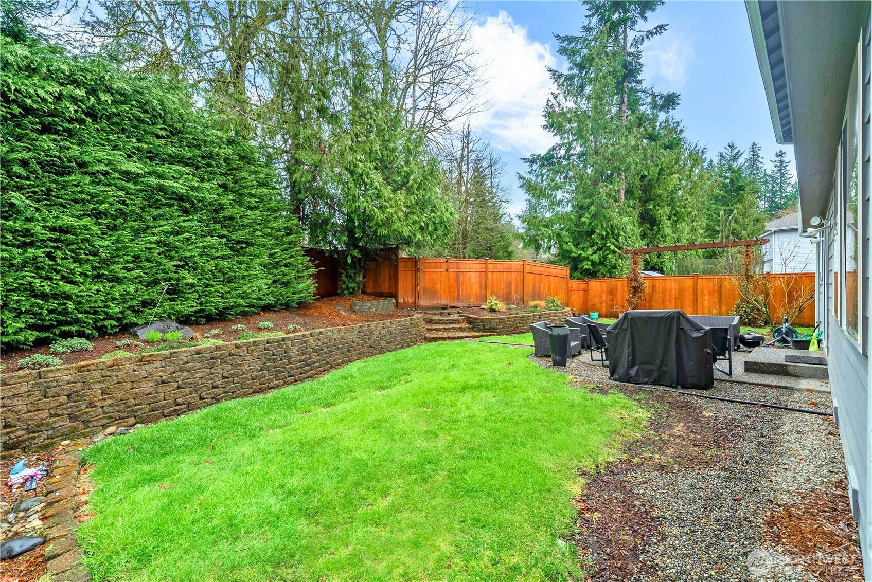 25010 235th Court Southeast Maple Valley, WA 98038 - Photo 37 of 40 a view of a backyard with a garden and a slide