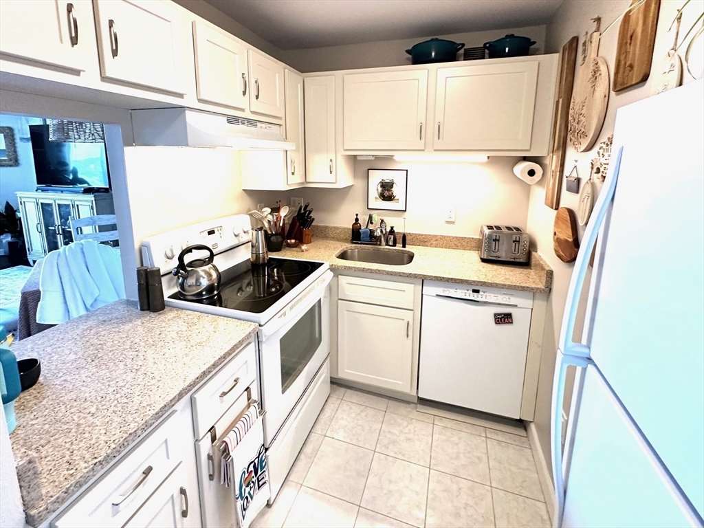 77 Adams Street, Unit 902 Quincy, MA 02169 - Photo 11 of 36 a kitchen with a sink a stove and cabinets