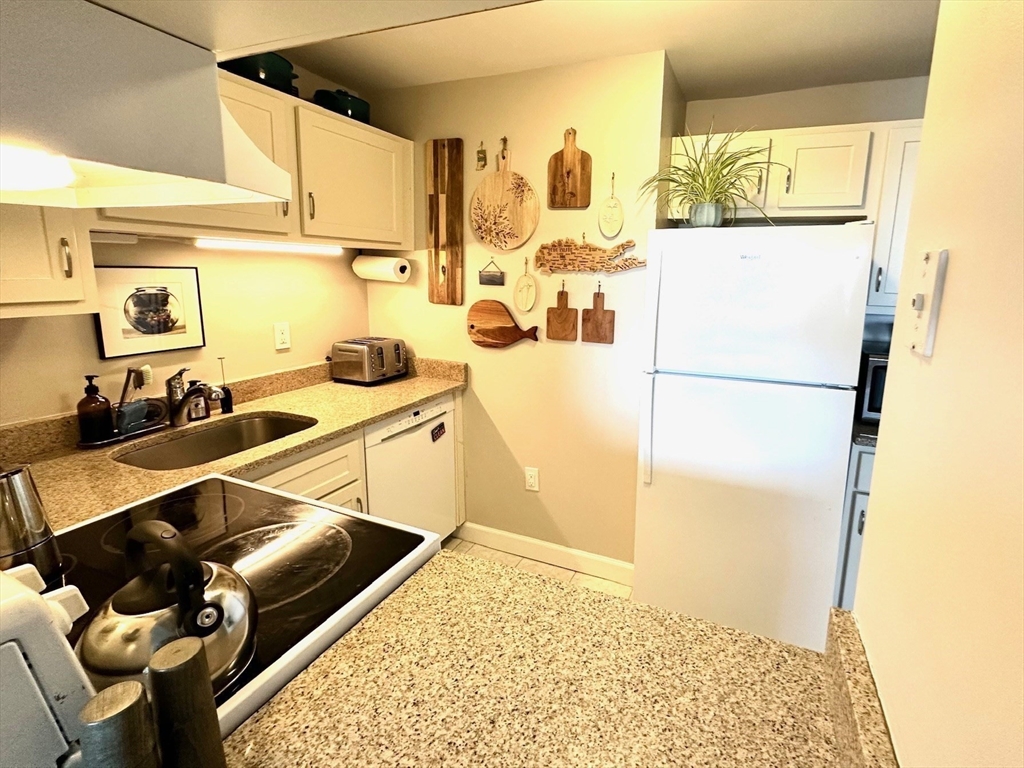 77 Adams Street, Unit 902 Quincy, MA 02169 - Photo 12 of 36 a kitchen with a refrigerator and a stove top oven