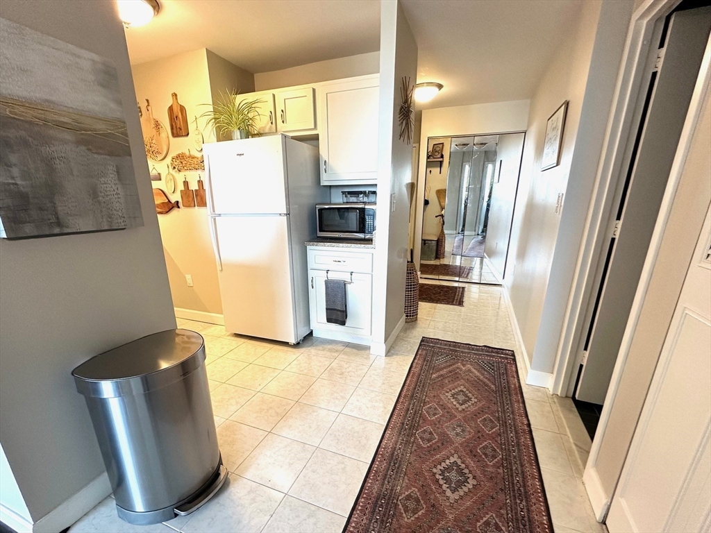 77 Adams Street, Unit 902 Quincy, MA 02169 - Photo 9 of 36 a refrigerator freezer sitting inside of a kitchen