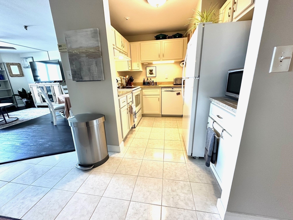 77 Adams Street, Unit 902 Quincy, MA 02169 - Photo 10 of 36 a kitchen with stainless steel appliances granite countertop a refrigerator sink and cabinets