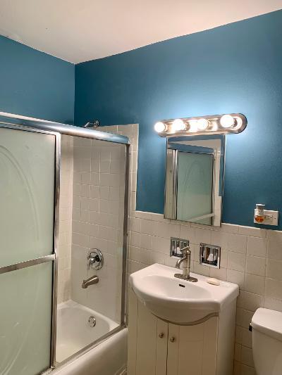 7019 North Ridge Boulevard, Unit 2C Chicago, IL 60645 - Photo 11 of 12 a bathroom with a sink a mirror and a bathtub