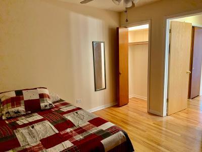 7019 North Ridge Boulevard, Unit 2C Chicago, IL 60645 - Photo 8 of 12 a bedroom with a bed and wooden floor