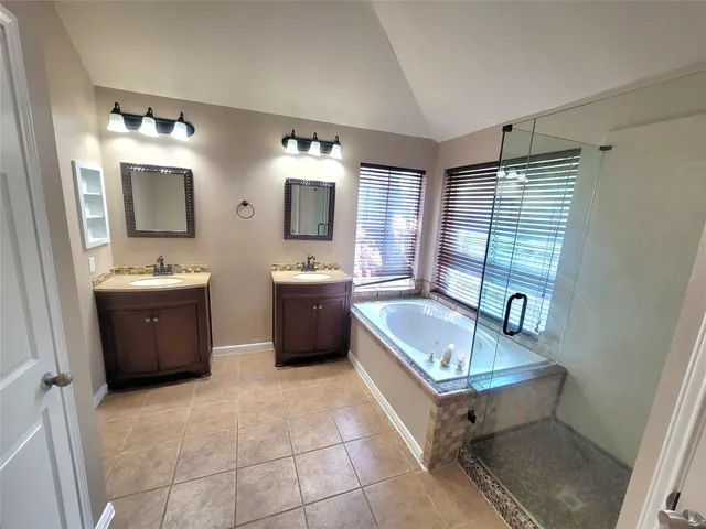a bathroom with a tub sink and mirror