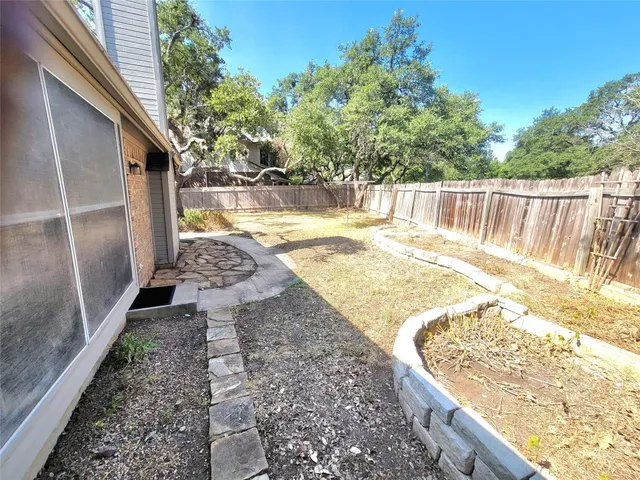 a view of a backyard with wooden fence and floor