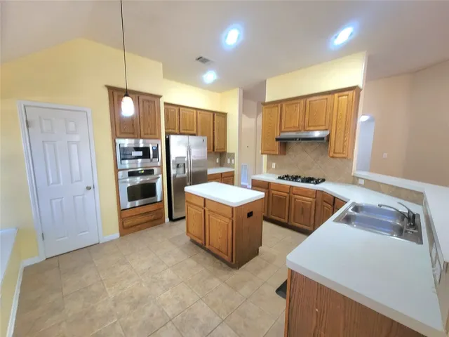 a kitchen with sink refrigerator and stove