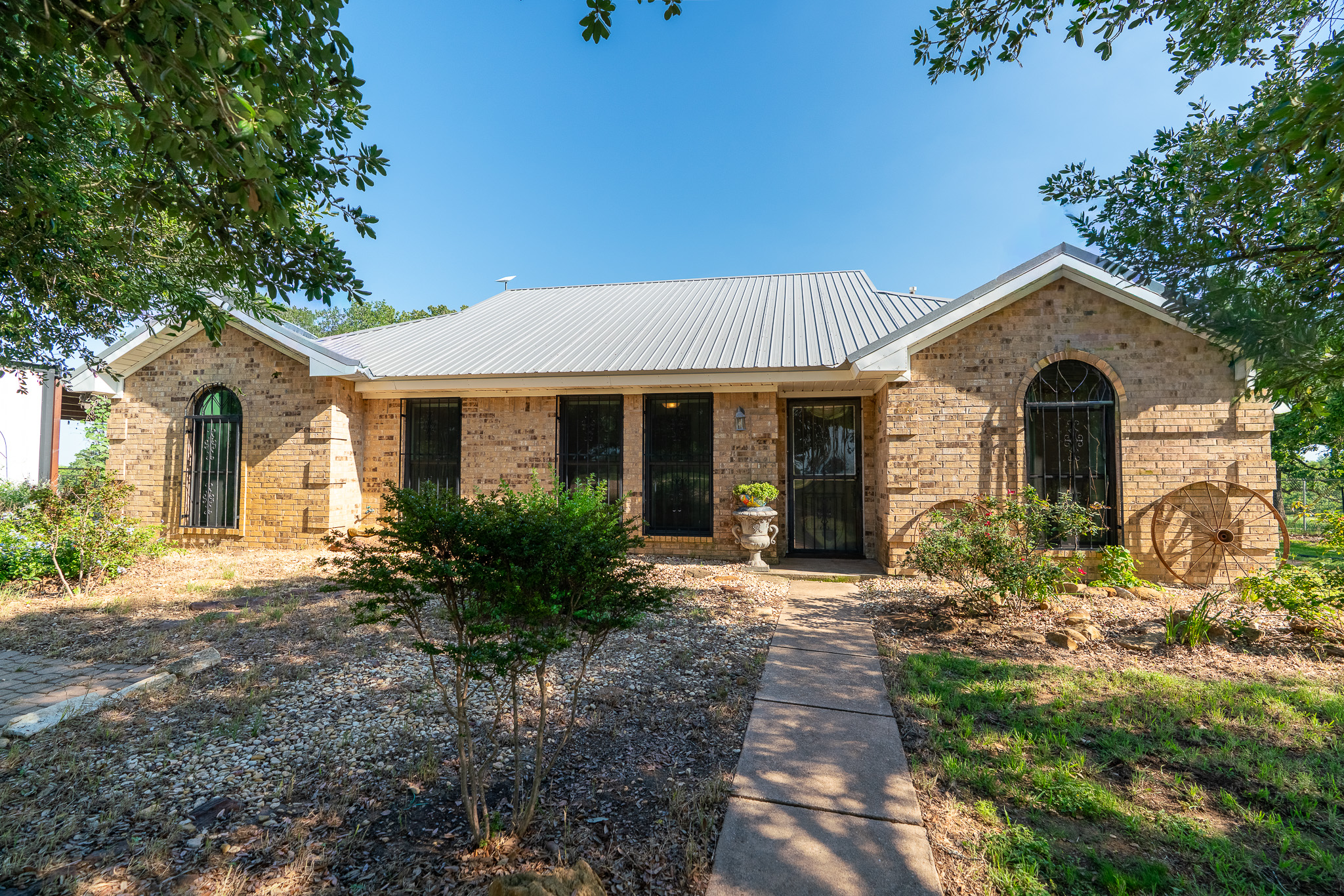 400 619th Spur Elgin, TX 78621 - Photo 21 of 40 Brick facade with arched windows and a practical metal roof create a welcoming curb appeal.