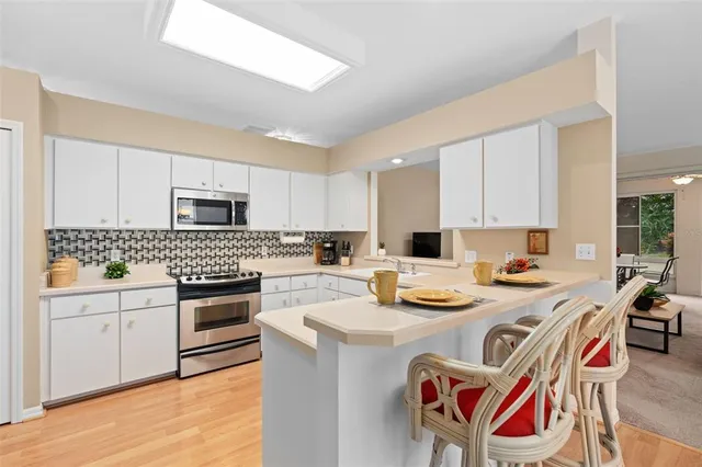 a kitchen with stainless steel appliances granite countertop a stove and white cabinets