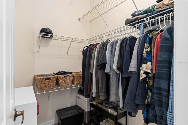 a view of walk in closet with clothes and shoes