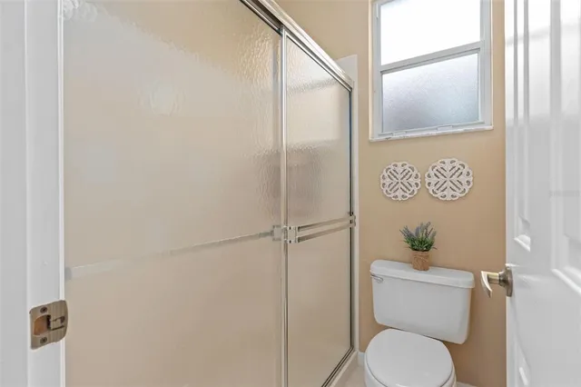 a bathroom with a toilet and a shower