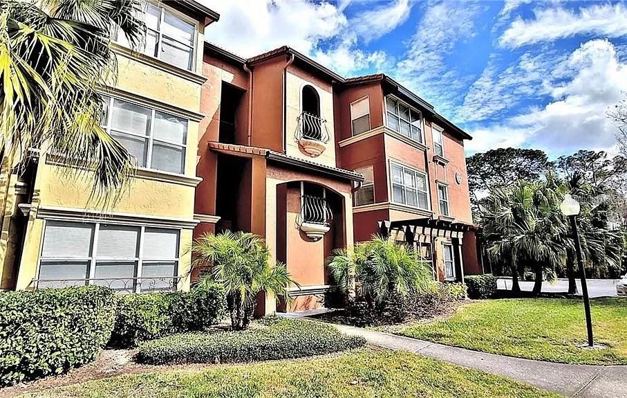 5156 Conroy Road, Unit 1138 Orlando, FL 32811 - Photo 1 of 1 a front view of a residential apartment building with a yard