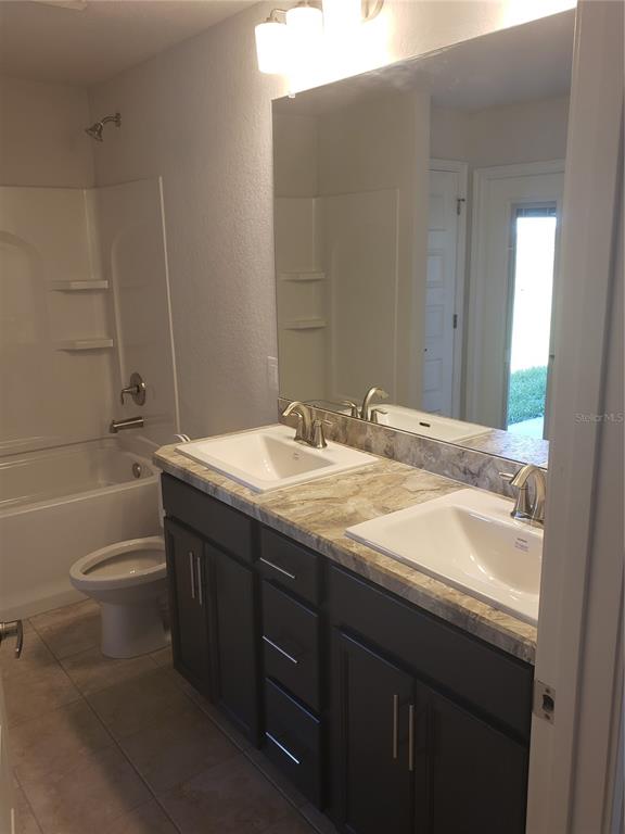 278 Waterfall Drive Spring Hill, FL 34608 - Photo 14 of 16 a bathroom with a granite countertop sink a toilet and bathtub