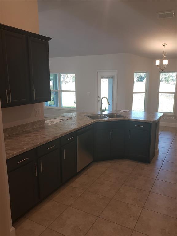 278 Waterfall Drive Spring Hill, FL 34608 - Photo 8 of 16 a kitchen with granite countertop a sink and a stove