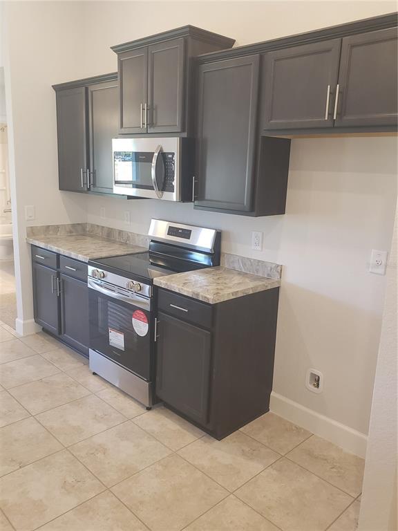 278 Waterfall Drive Spring Hill, FL 34608 - Photo 9 of 16 a kitchen with stainless steel appliances granite countertop a stove and a microwave