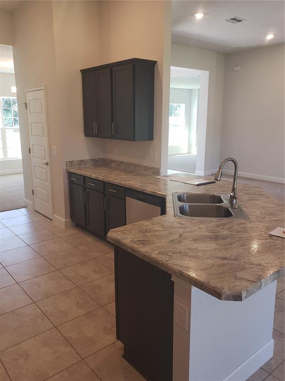 278 Waterfall Drive Spring Hill, FL 34608 - Photo 10 of 16 a kitchen with a sink a stove and cabinets