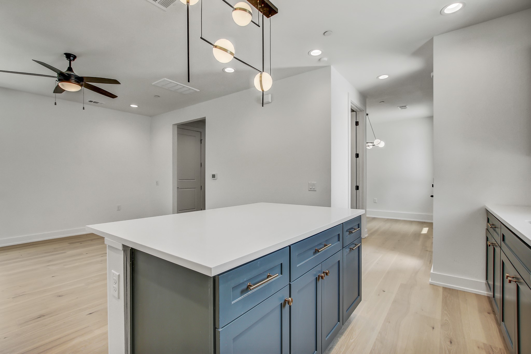 4127 East 12th Street, Unit 5 Austin, TX 78721 - Photo 14 of 33 Kitchen with a ceiling fan, light wood finished floors, a kitchen island, recessed lighting, and baseboards