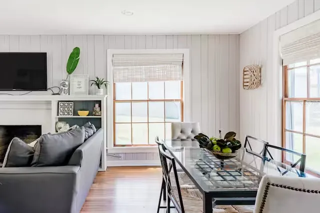 a living room with furniture a fireplace a flat screen tv and a window