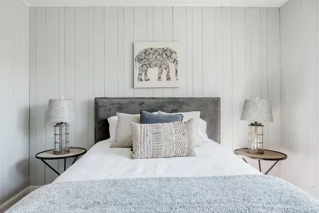 a bed sitting in a bedroom and table chair