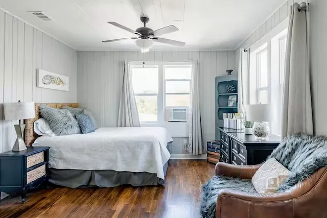 a bedroom with a bed and wooden floor
