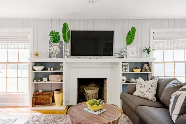 a living room with furniture a fireplace and a flat screen tv