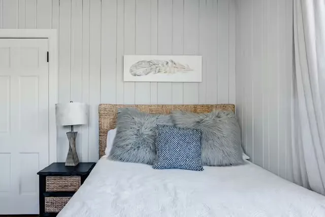 a bedroom with a bed and a painting on the wall