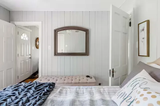 a bedroom with a bed and a mirror