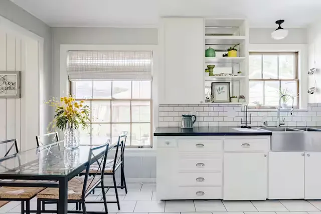 a kitchen with granite countertop white cabinets and window