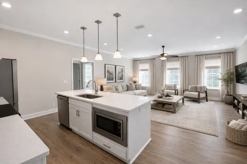 a kitchen with kitchen island a stove a sink a refrigerator and chairs
