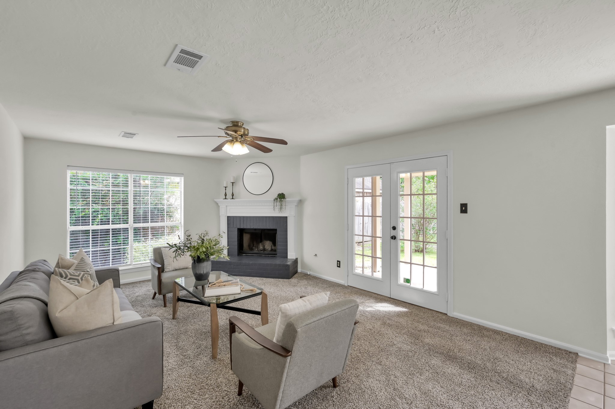 114 Regency Way Conroe, TX 77304 - Photo 11 of 48 Spacious, light and bright living room with cozy wood/gas fire place, double doors leading to covered back patio and ceiling fan.