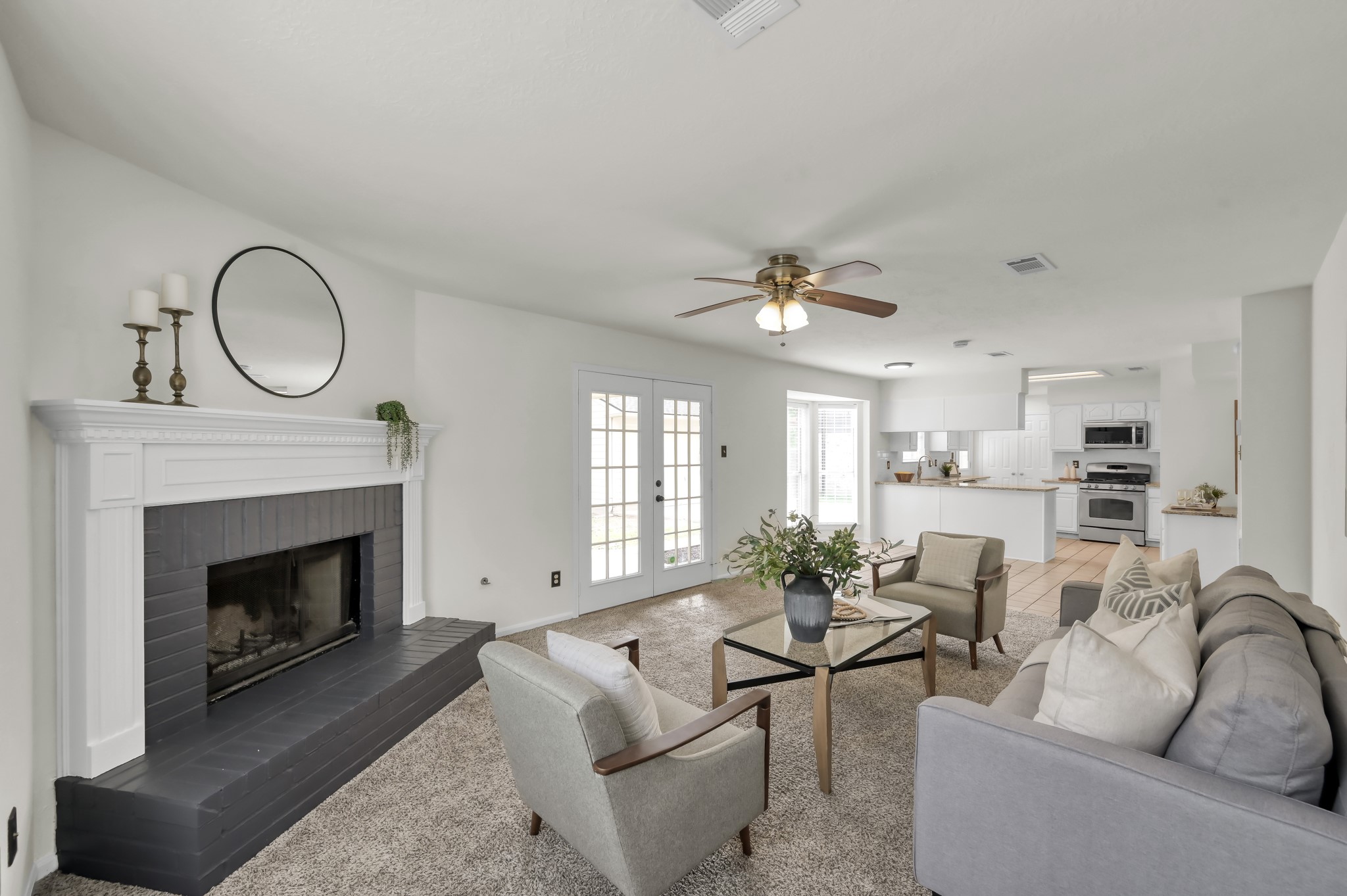 114 Regency Way Conroe, TX 77304 - Photo 12 of 48 Spacious, light and bright living room with cozy wood/gas fire place, double doors leading to covered back patio and ceiling fan.