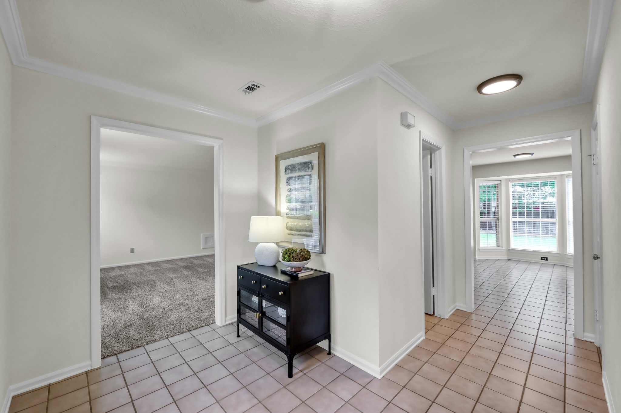 114 Regency Way Conroe, TX 77304 - Photo 5 of 48 Light and bright entryway with crown molding and tile flooring. To the left is a large flex room that can accomodate a home office, home school, or game/play room.