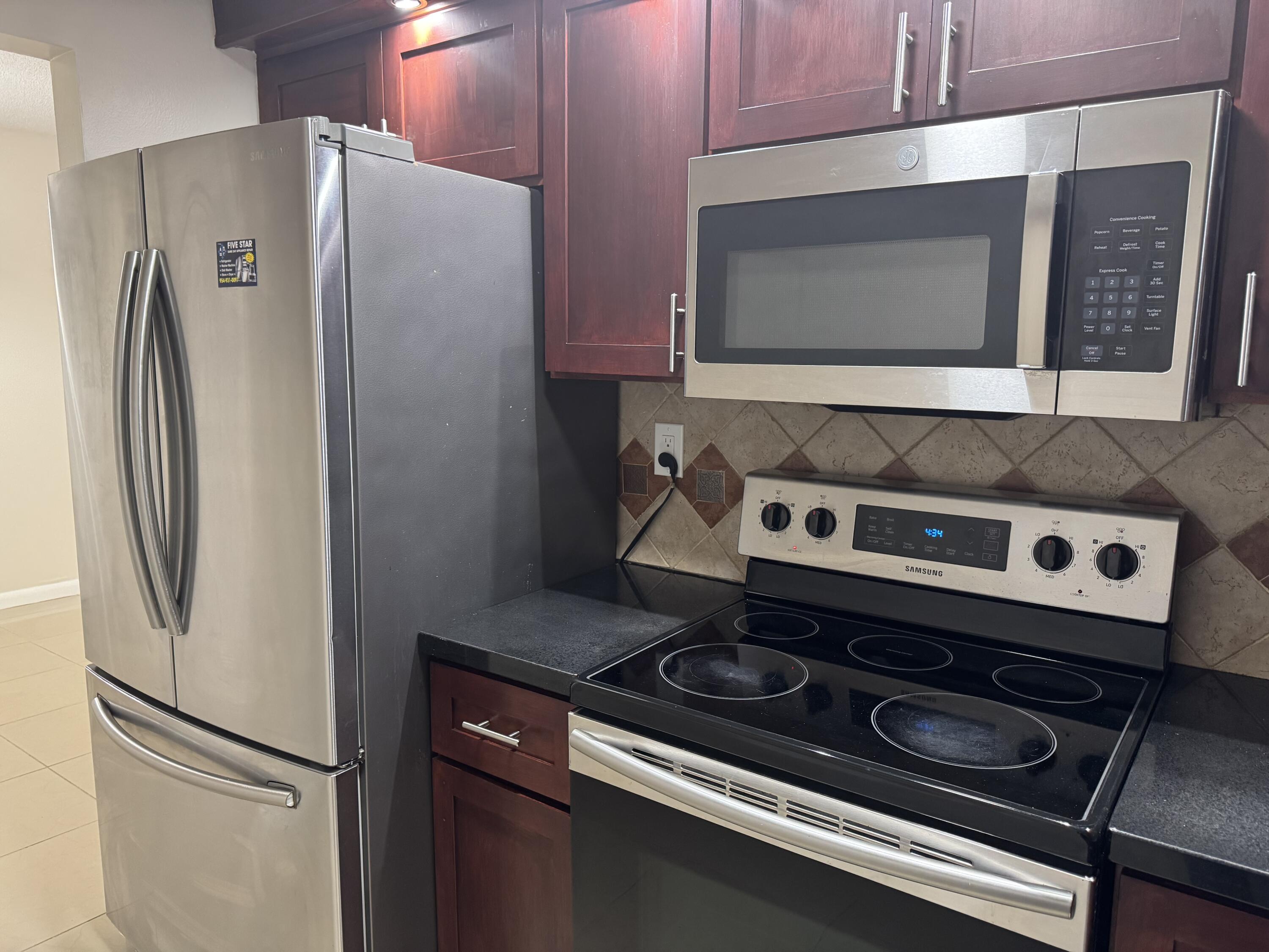 3710 North Pine Island Road, Unit 122 Sunrise, FL 33351 - Photo 11 of 39 a kitchen with a refrigerator and a microwave
