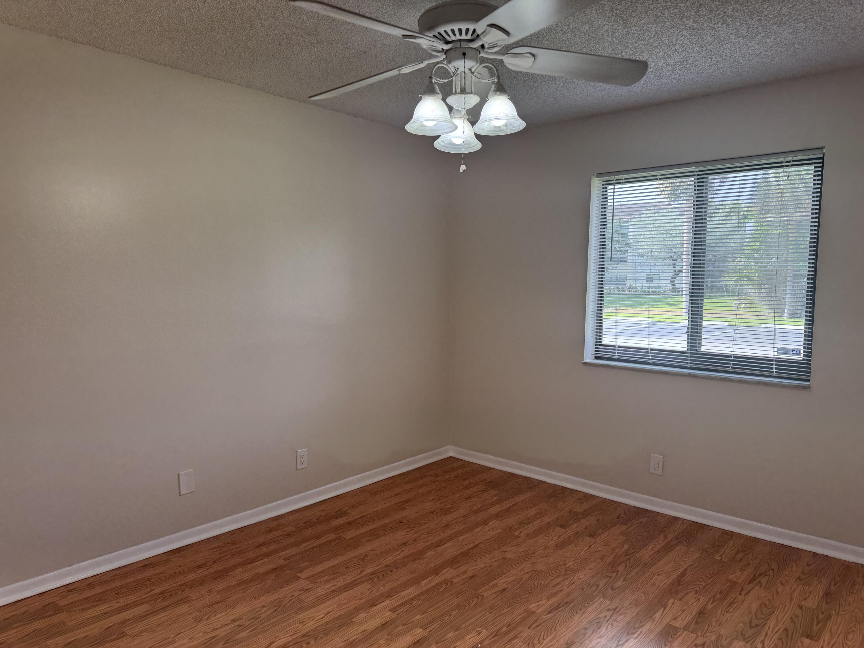 3710 North Pine Island Road, Unit 122 Sunrise, FL 33351 - Photo 14 of 39 a view of an empty room with wooden floor and a window