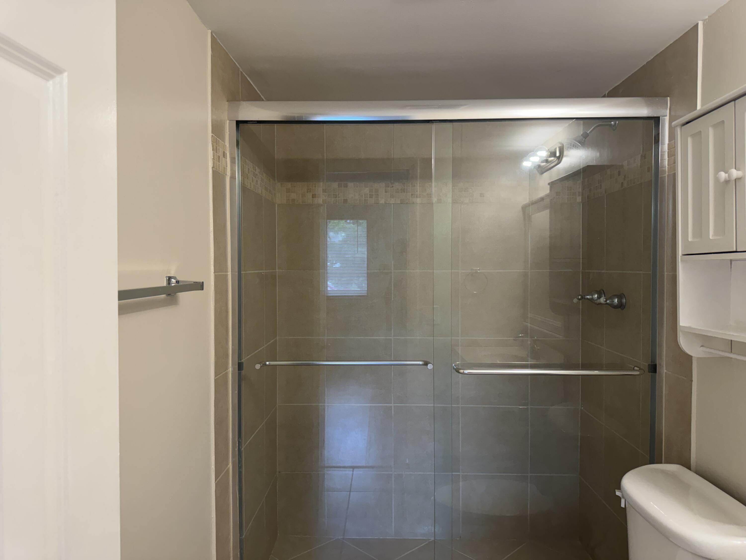 3710 North Pine Island Road, Unit 122 Sunrise, FL 33351 - Photo 20 of 39 a bathroom with a glass shower door