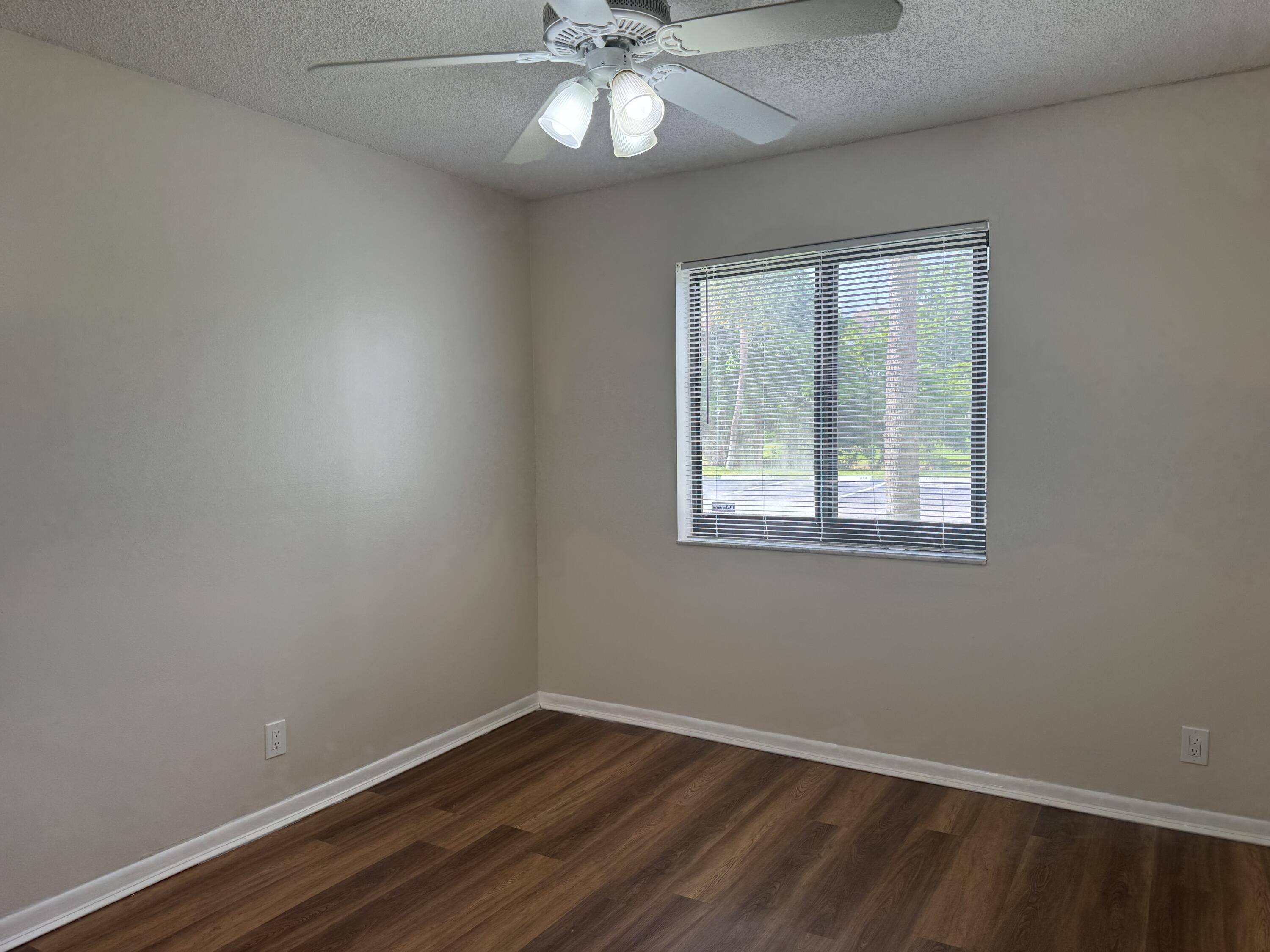 3710 North Pine Island Road, Unit 122 Sunrise, FL 33351 - Photo 21 of 39 an empty room with a window and wooden floor