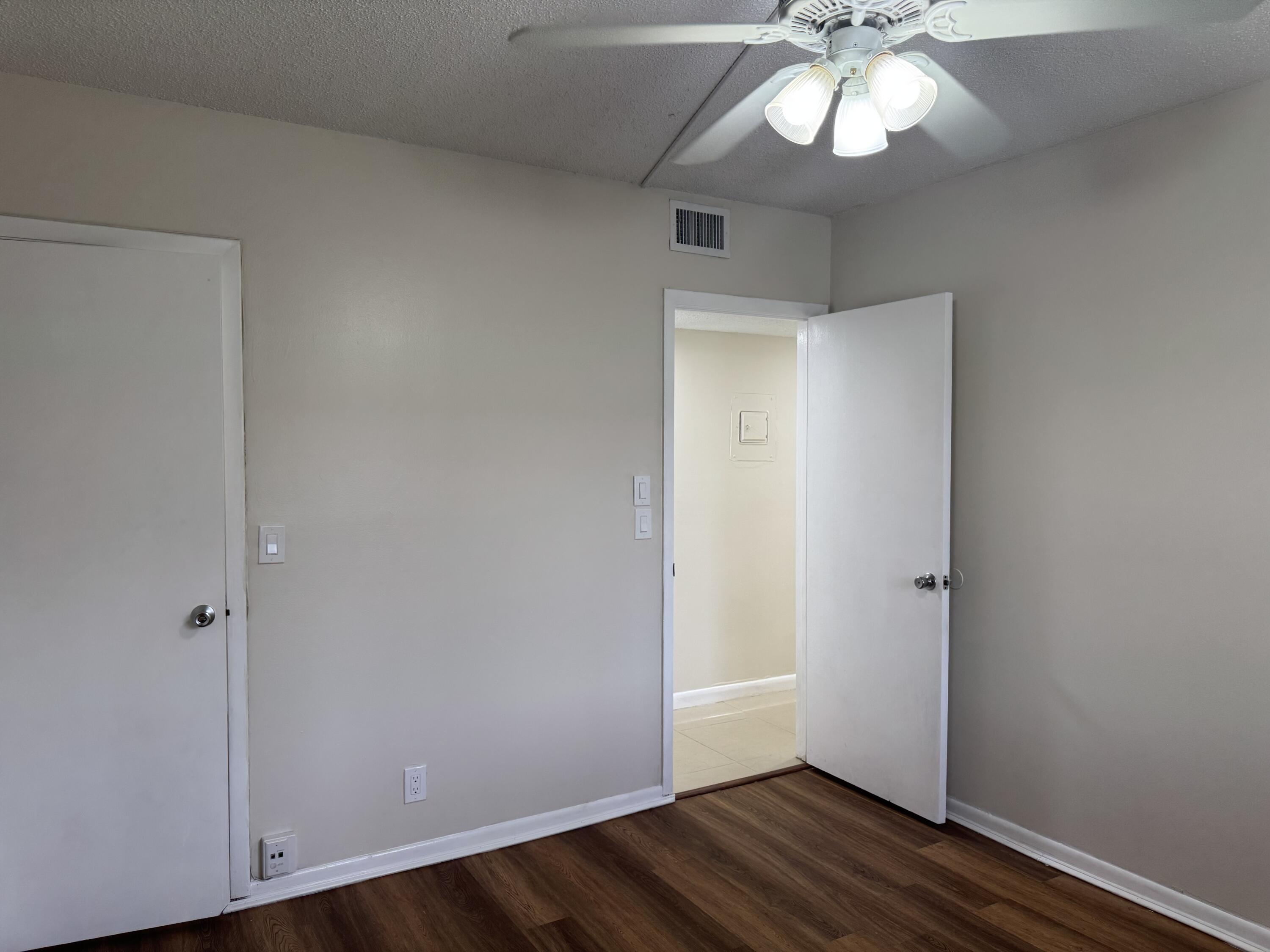 3710 North Pine Island Road, Unit 122 Sunrise, FL 33351 - Photo 23 of 39 an empty room with wooden floor and chandelier fan