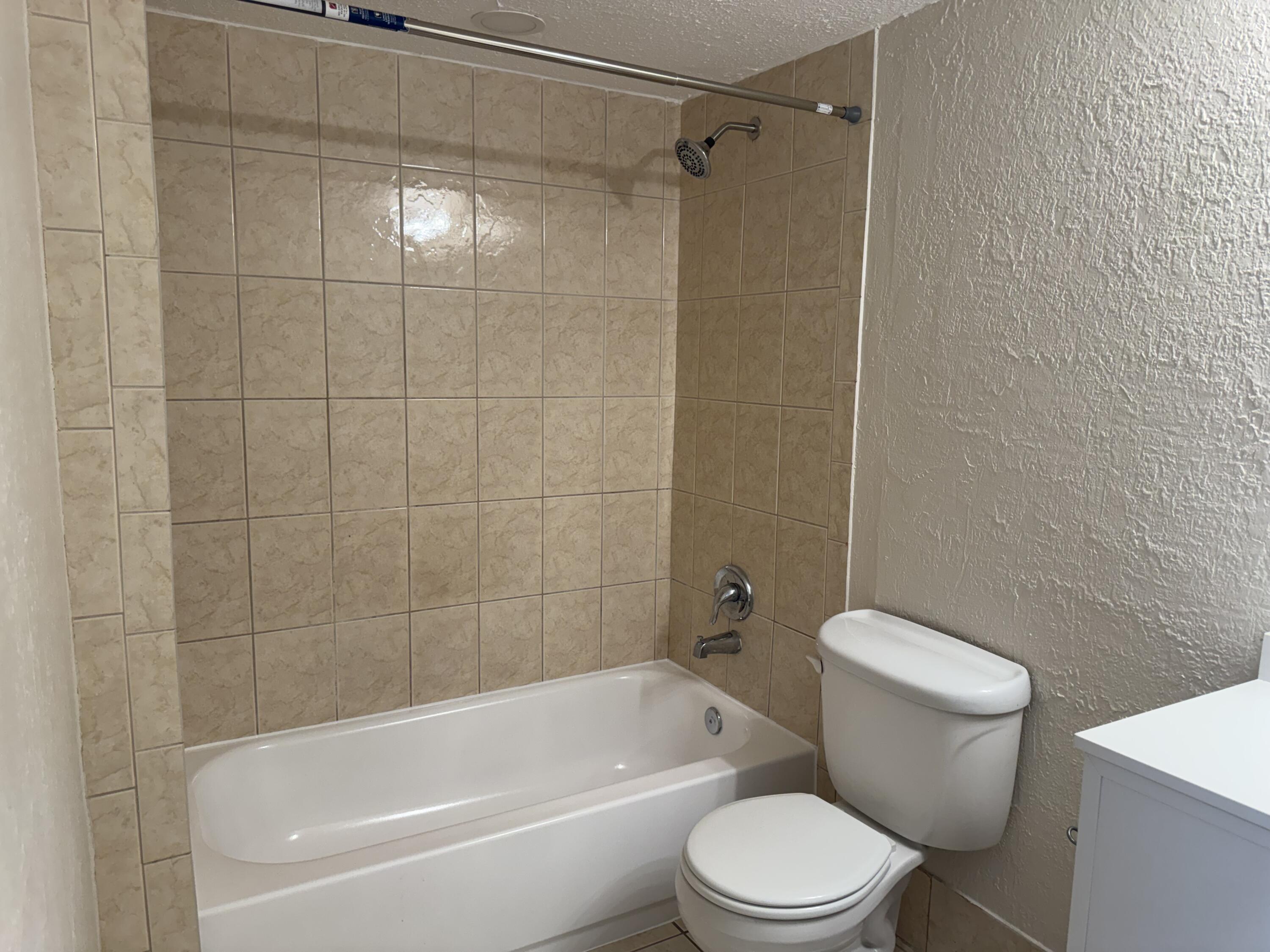 3710 North Pine Island Road, Unit 122 Sunrise, FL 33351 - Photo 29 of 39 a white toilet and tub sitting next to a bathroom sink