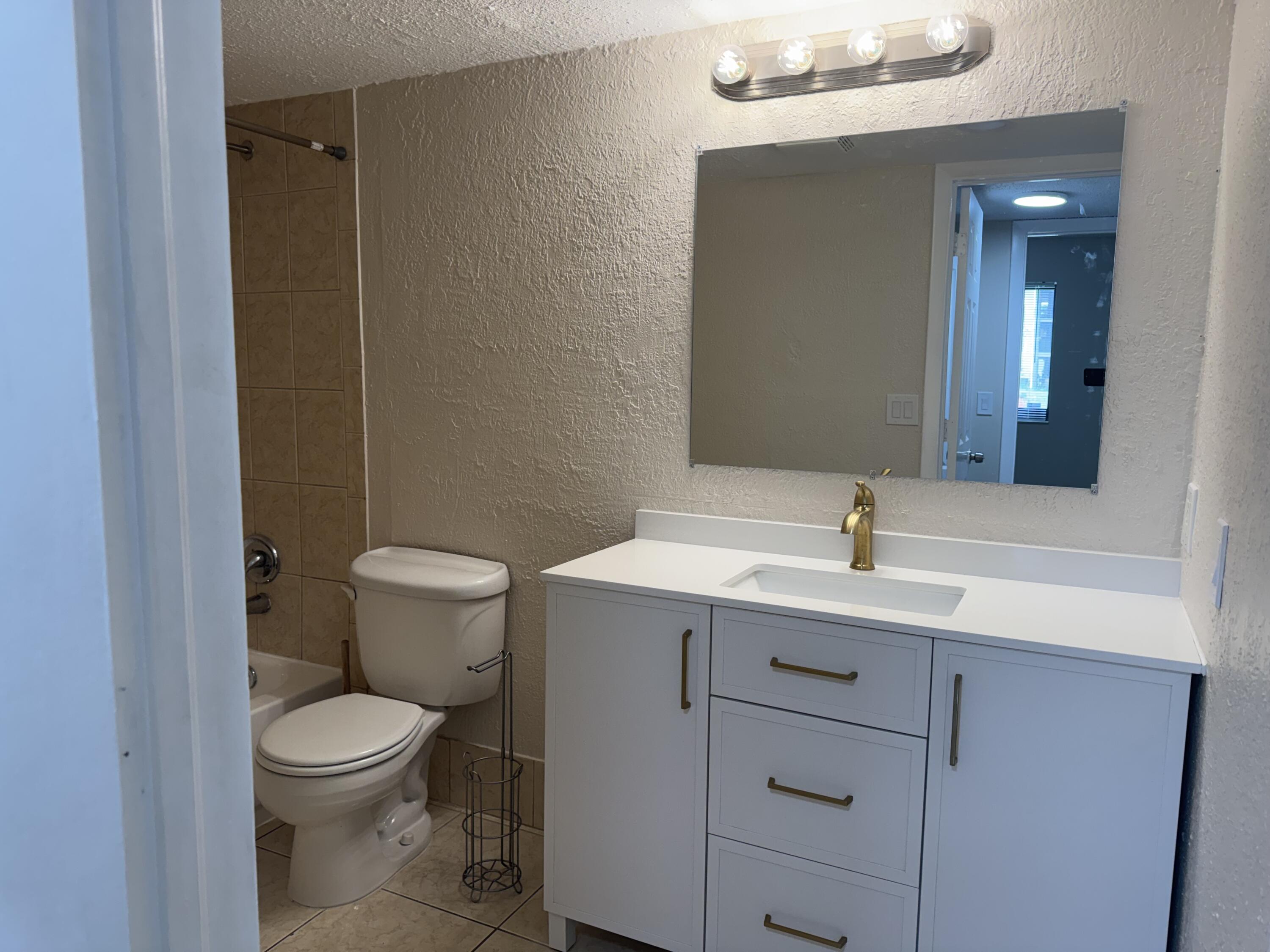 3710 North Pine Island Road, Unit 122 Sunrise, FL 33351 - Photo 30 of 39 a bathroom with a toilet a sink and mirror