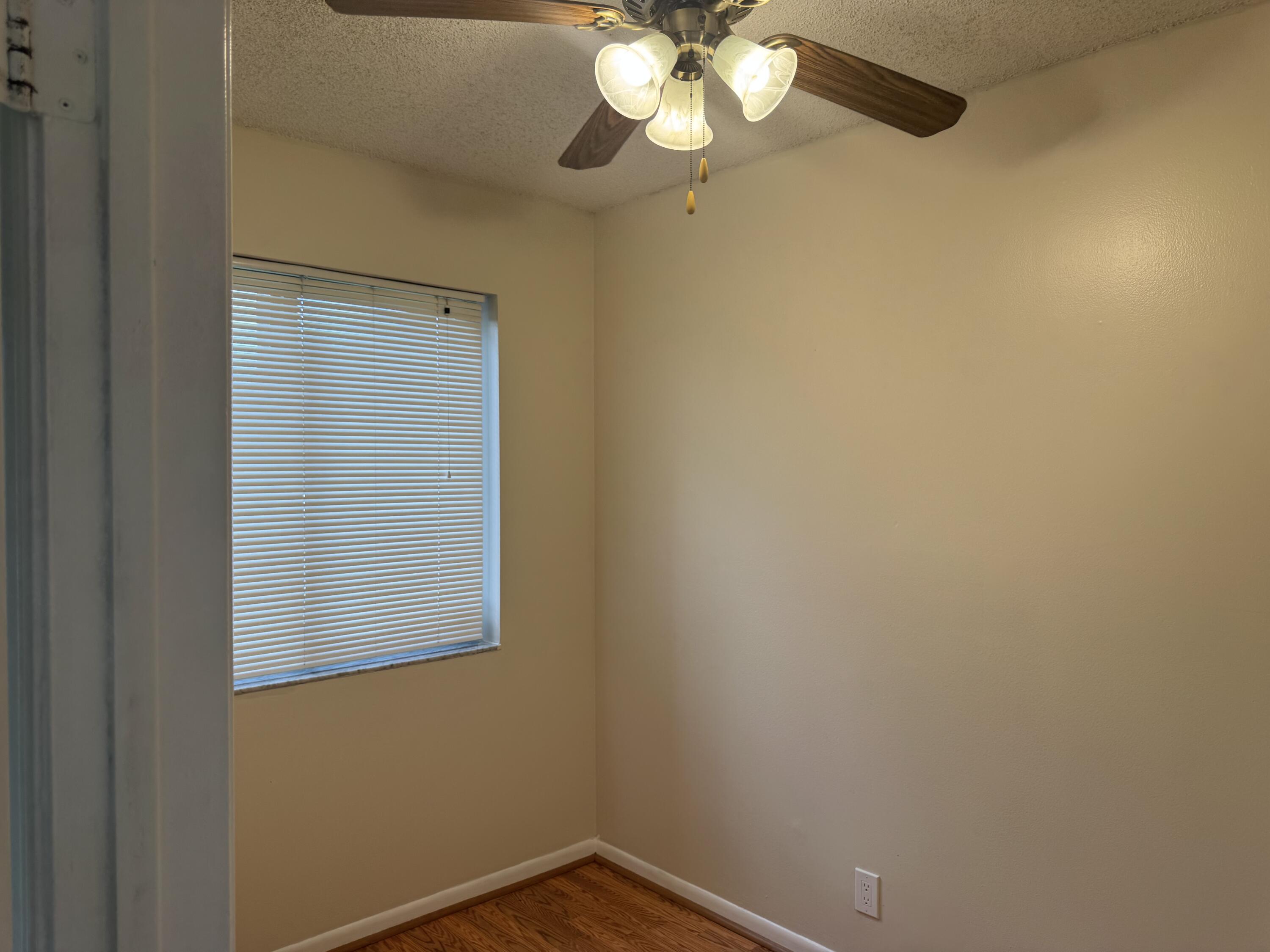 3710 North Pine Island Road, Unit 122 Sunrise, FL 33351 - Photo 31 of 39 an empty room with a window and a chandelier fan