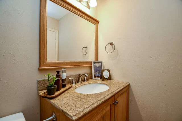 a bathroom with a granite countertop sink and a mirror